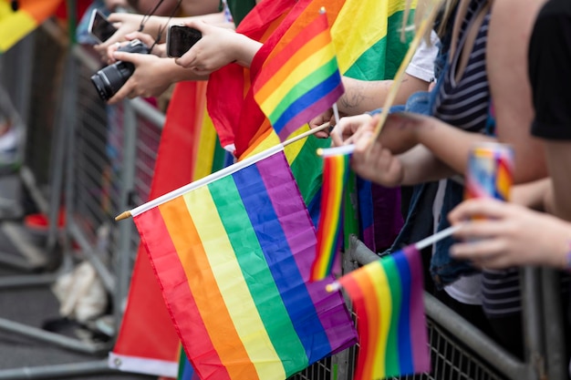 Spectators waves a gay rainbow flag at an lgbt gay pride community event