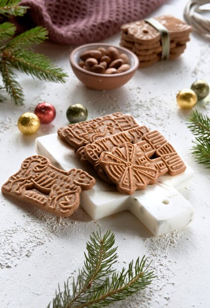 Speculoos of Spekulatius Kerstkoekjes chocoladebolletjes en amandelen op een tafel met dennentakjes Traditionele Duitse snoepkoekjes voor kerst- of adventswintersnacks