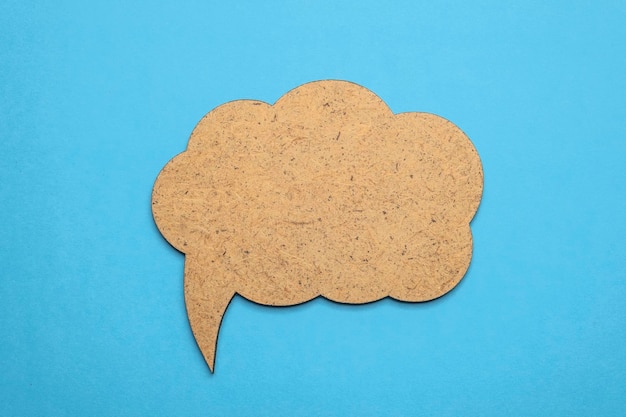 Speech bubble crepe paper balloon label on blue background Copy space