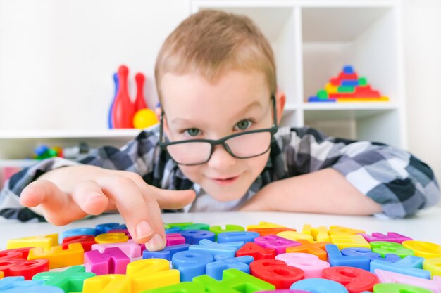 Logoterapia. ragazzo del bambino con le lettere. lezioni con logopedista.