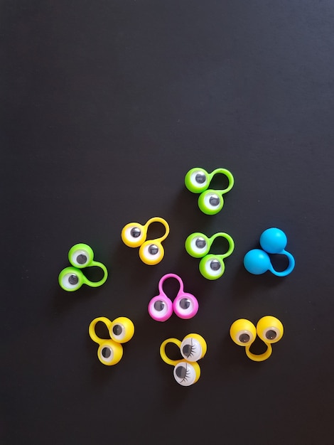 Логопедические игрушки глаза на пальцах на черном изолированном фоне