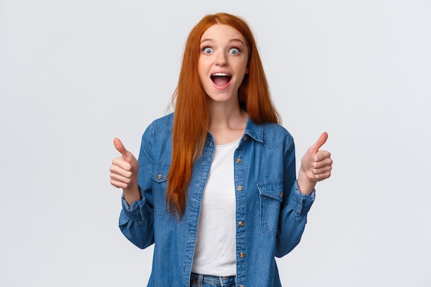 Speechless, excited and impressed redhead female cheering for friend scored goal, achieved success, great teamwork brought positive result, showing thumbs-up smiling and scream happy surprised