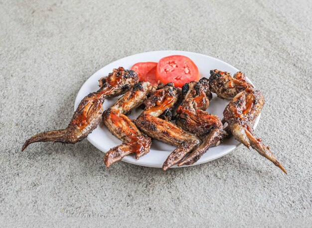 Speed chicken chilli wings with served in a dish isolated on grey background side view of fast food