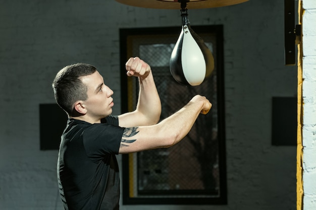 Speed matters. Portrait of a professional boxer practicing punching with the speed bag