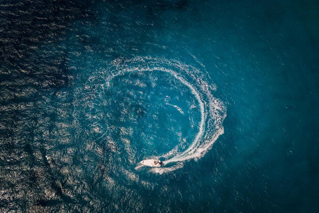 Speed motor boat creating cyrcle at sea Aerial view from drone