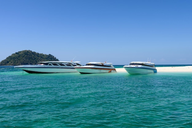 Speedboot aan de kust met wit zand in de smaragdgroene zee