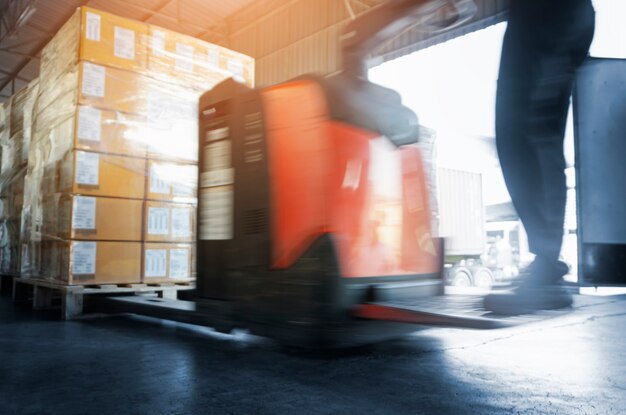 Speeding Motion of Worker Driving Electric Forklift to Unloading Package Boxes at the Warehouse