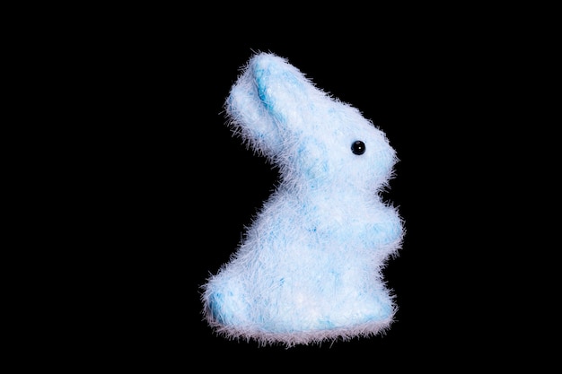 Foto speelgoed blauwe haas geïsoleerd op zwarte achtergrond. pluizig konijn. pasen. hoge kwaliteit foto