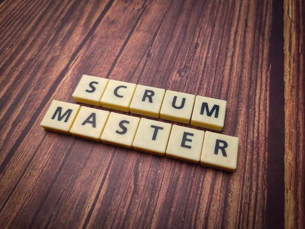 Speelgoed woord met de letters SCRUM MASTER op een houten achtergrond