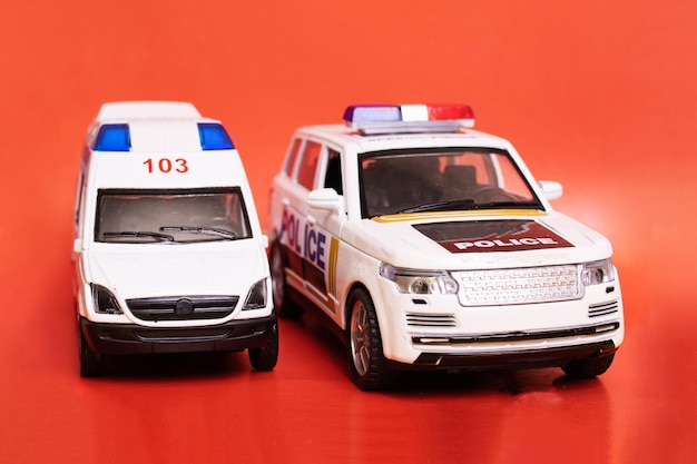 Speelgoedambulances en politieauto's op rode achtergrond