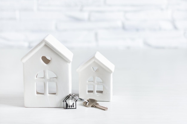 Speelgoedhuis en sleutel met sleutelhanger met familie in de vorm van een huis Vastgoedmarktconcept