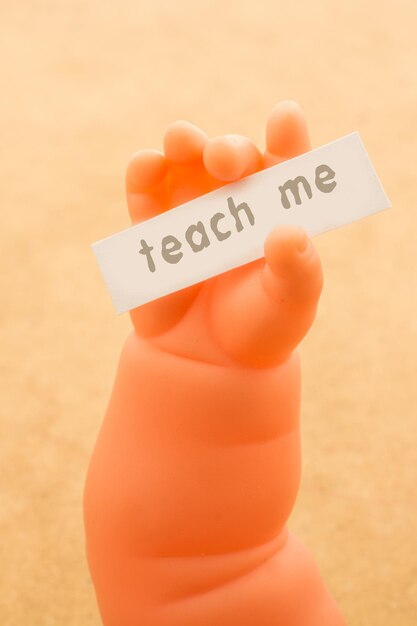 Speelgoedpop hand met papier met teach me formulering