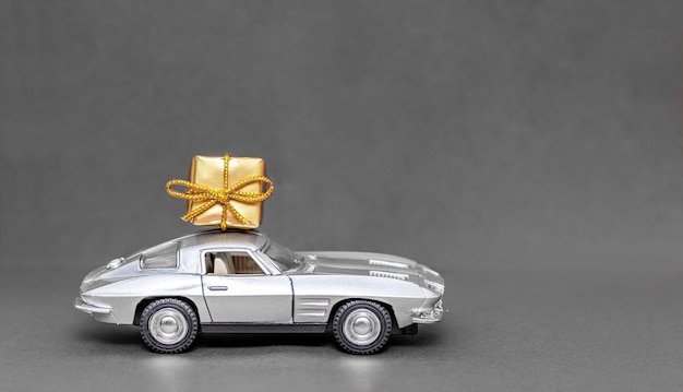Speelgoedretoro-auto met een geschenkdoos. levering van geschenken