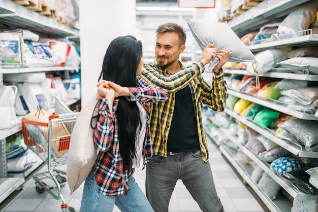 Speels paar in supermarkt, kussengevecht