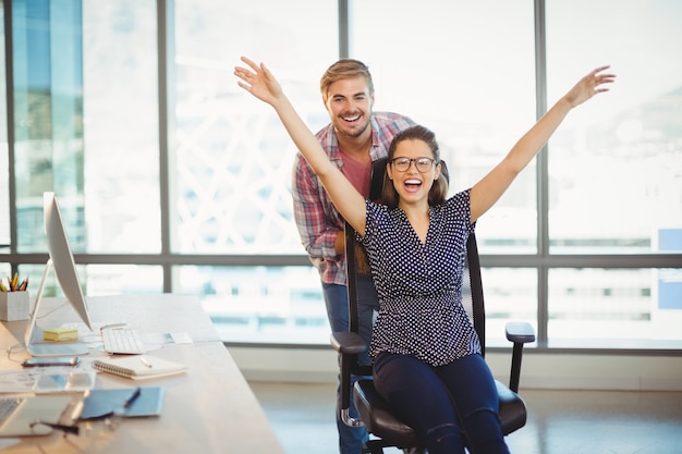 Speelse man duwt zijn collega op bureaustoel