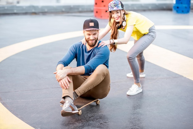 Speelse vrienden plezier samen schaatsen op het skateboard buiten op de speelplaats