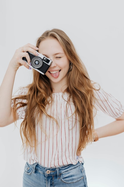 Speelse vrouw die een foto maakt met een filmcamera