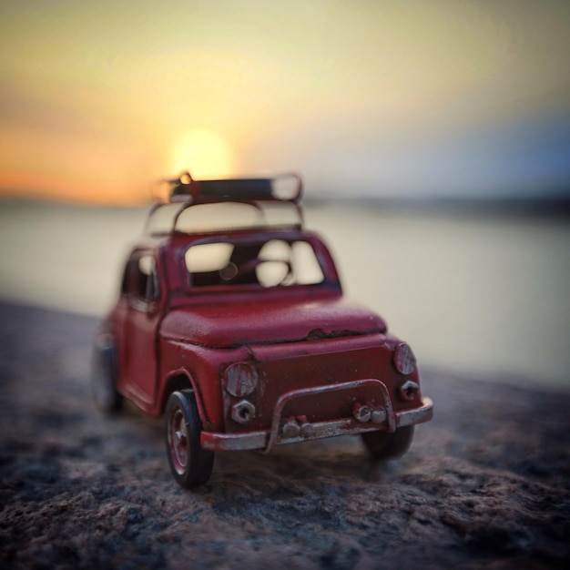 Foto speelwagen op het strand bij zonsondergang