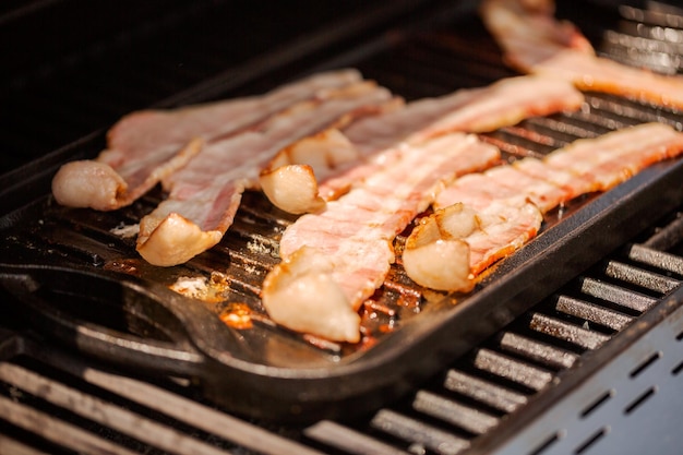 Spekreepjes grillen op gietijzeren bakplaat in buitengasgrill.