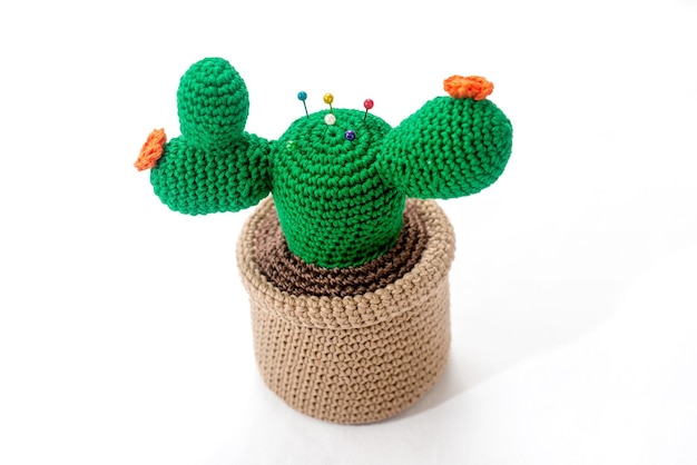 Speldenkussen in de vorm van een cactus in een pot gehaakt op een witte achtergrond