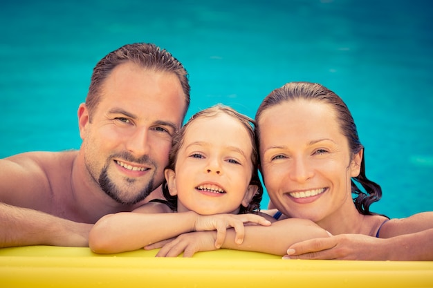 Spelen in zwembad en gelukkige familie