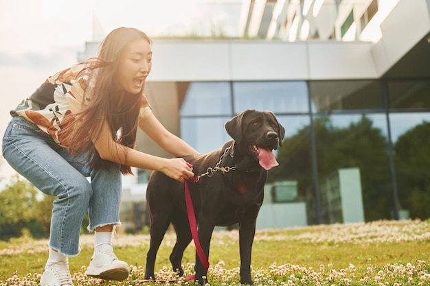 Spelen met hond Jonge Aziatische vrouw is overdag buiten