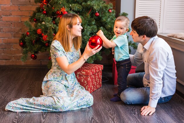 Spelen met kerstballen thuis en gelukkige familie