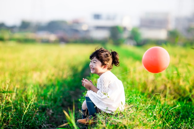 Spelen van het meisje met ballons op tarweveld