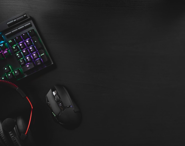 spelen vanuit huis concept, bovenaanzicht een gaming-uitrusting, muis, toetsenbord, joystick, headset, mobiele joystick, in-ear hoofdtelefoon en muismat op zwarte tafel achtergrond met kopie ruimte.