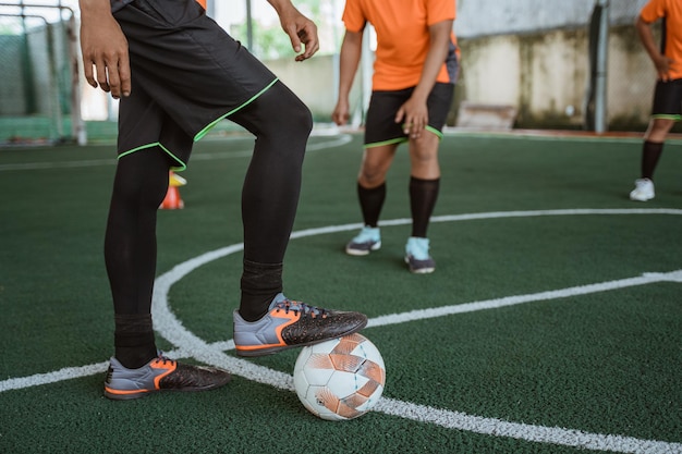 Foto spelers met zaalvoetbalschoenen en bal tijdens een zaalvoetbalwedstrijd