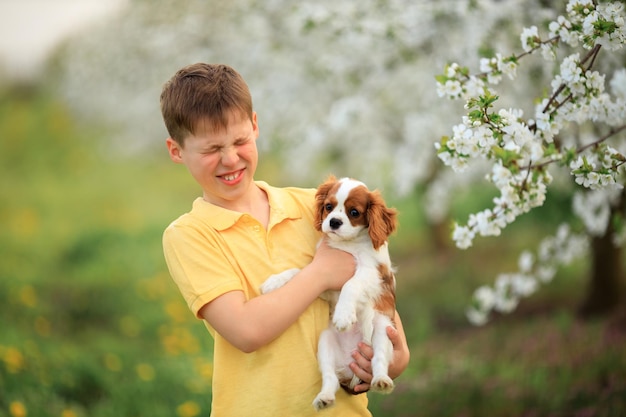 Spelletjes met een huisdier op straat jongen die loopt en plezier heeft met zijn spanielpuppy