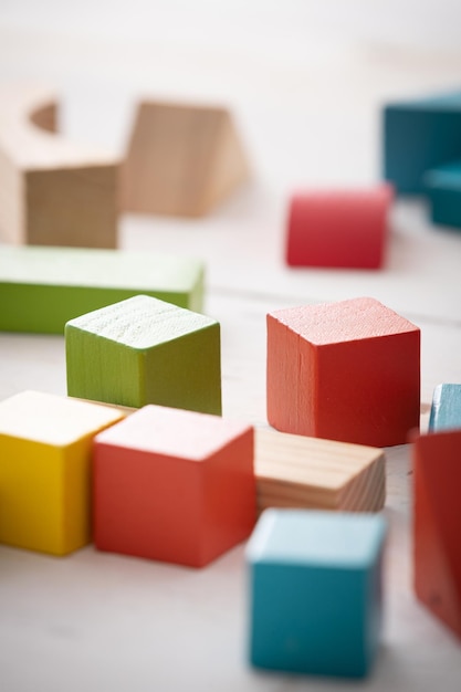 Spelletjes met kleurrijke houten stenen op een witte houten tafel Het kind speelt met geometrische vormen gemaakt van natuurlijk hout Leer- en onderwijsconcept