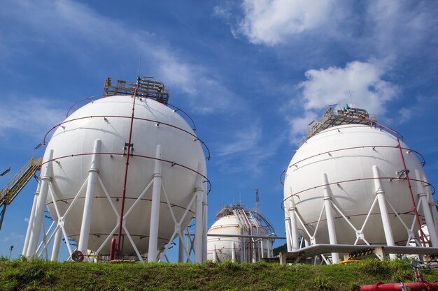 Spherical tanks white containing fuel gas oil refineries blue sky