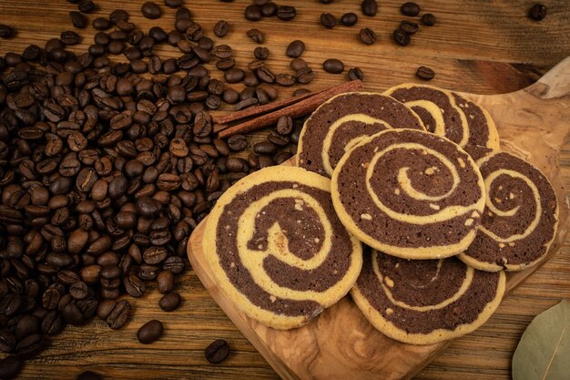 Spice cinnamon cookie with chocolate, coffee and nuts filling on wood background top view. Brown and white round soft biscuits, ginger molasses cookies, christmas gingersnap