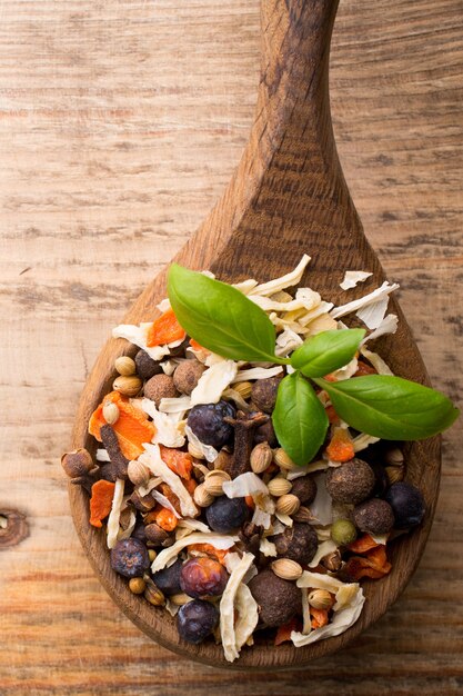 Spice mix a wooden spoon on a wooden background.