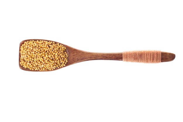 Spice mustard seeds in  wooden spoon isolated on a white background, top view