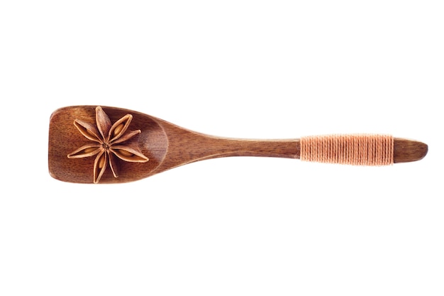 Spice Star anise in  wooden spoon isolated on a white background, top view