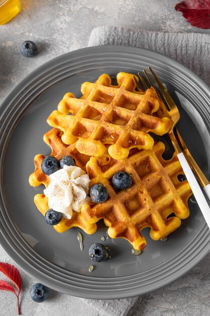 Waffle di zucca condite con miele di panna montata e mirtilli dessert per il giorno del ringraziamento