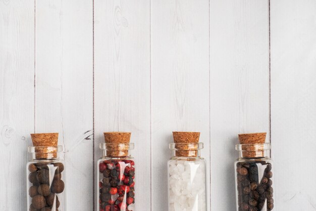 Фото Специи черный и красный перец и соль в стеклянных колбах