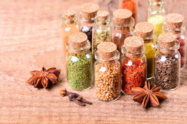 Spices in bottles on wooden background