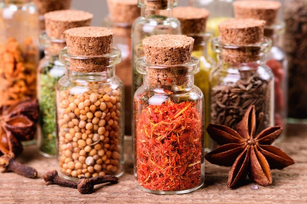 Spices in bottles on wooden background