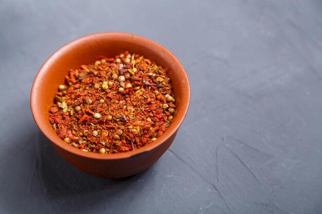 Spices in a brown bowl on a gray background save a place