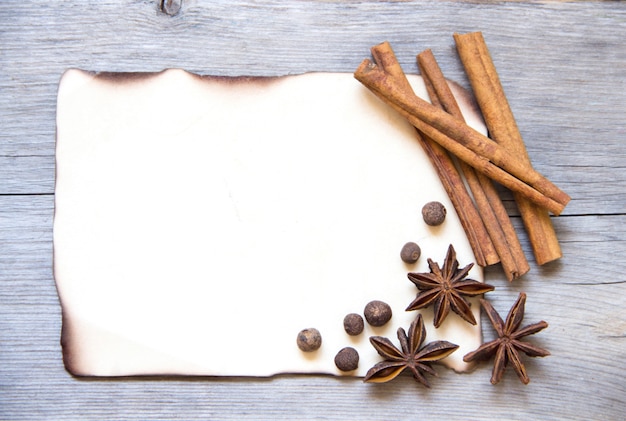 Foto spezie su una vista superiore di carta bruciata su una tavola di legno