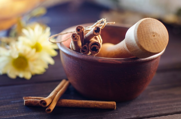 Spices, cinnamon sticks on the table near the mortar