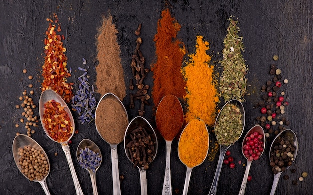 Spices and condiments for cooking on a black background.