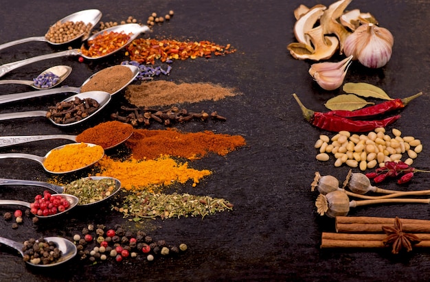 Spices and condiments for cooking on a black background.