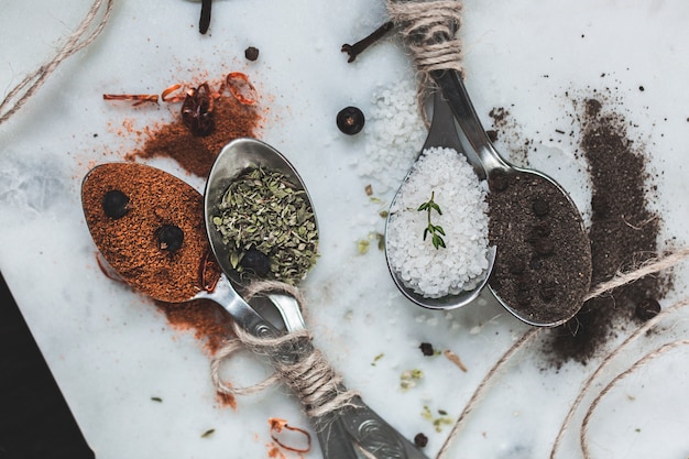 Spices in different spoons on stone marble table . Rustic vintage color toning