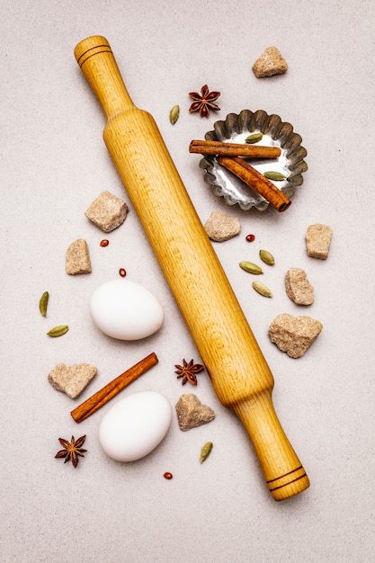 spices, eggs, brown lump sugar, cupcake baking dish and a rolling pin. Light