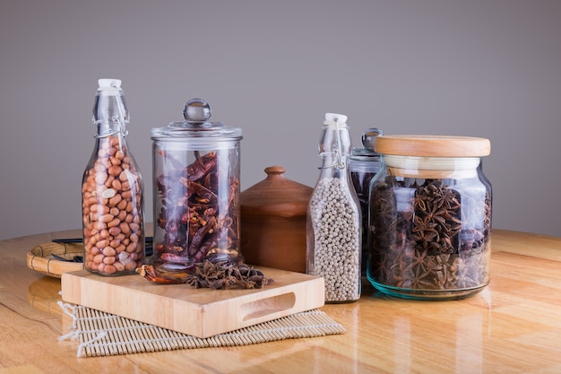 spices in glass bottles on wooden background.