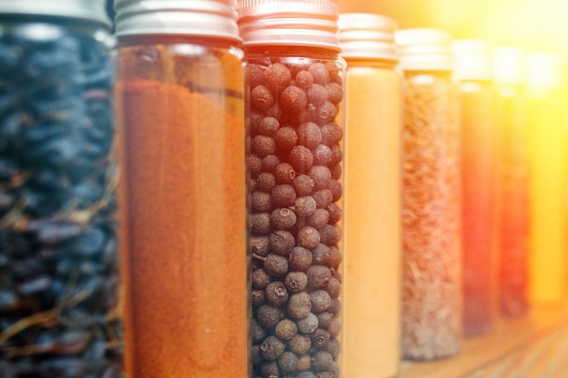 Spices and herbs of different colors in small jars Selective soft focus